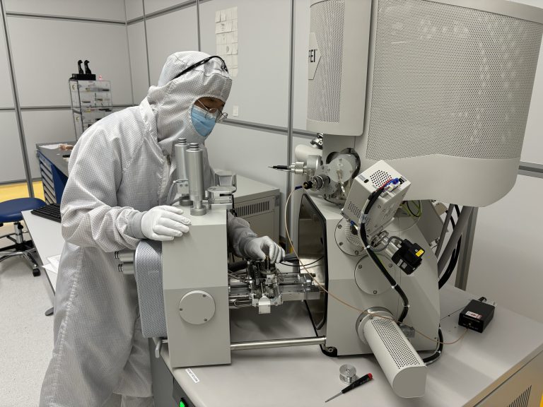 Dr. Byeon loads one of EeroQ’s Wonder Lake devices into a scanning electron microscope (SEM) at the Pritzker Nanofabrication Facility. The SEM allows him to view features on the device that are less than a micron wide and cannot be resolved in a typical optical microscope. Here, he uses control knobs to focus on the chip surface and determine whether the physical etching process he applied produces the smooth microchannels needed for single electron shuttling once those channels are filled with superfluid helium.