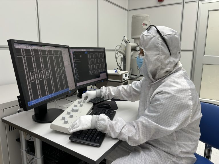 Dr. Byeon loads one of EeroQ’s Wonder Lake devices into a scanning electron microscope (SEM) at the Pritzker Nanofabrication Facility. The SEM allows him to view features on the device that are less than a micron wide and cannot be resolved in a typical optical microscope. Here, he uses control knobs to focus on the chip surface and determine whether the physical etching process he applied produces the smooth microchannels needed for single electron shuttling once those channels are filled with superfluid helium.